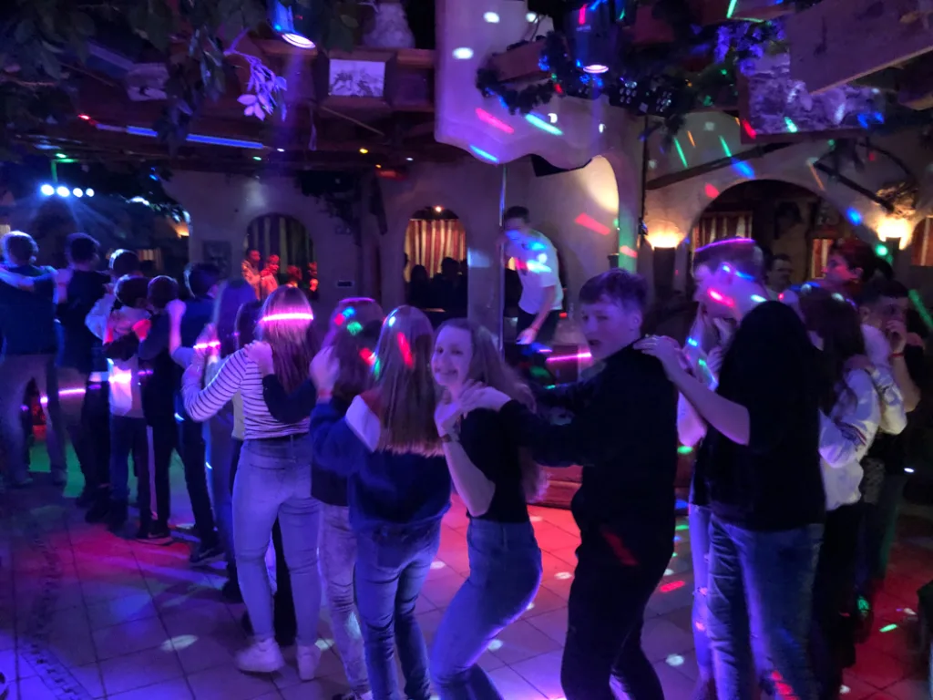 Volle Tanzfläche im Licht der Discobeleuchtung.